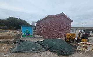 A building with a tarp and a tractor
AI-generated content may be incorrect.